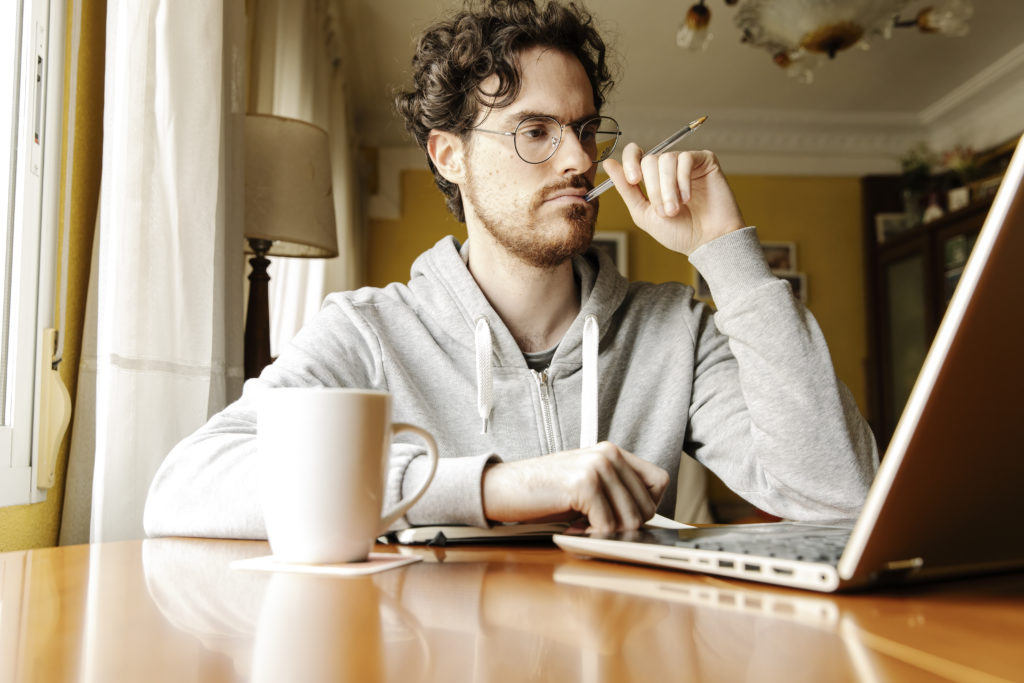 Thoughtful freelancer working with laptop at home
