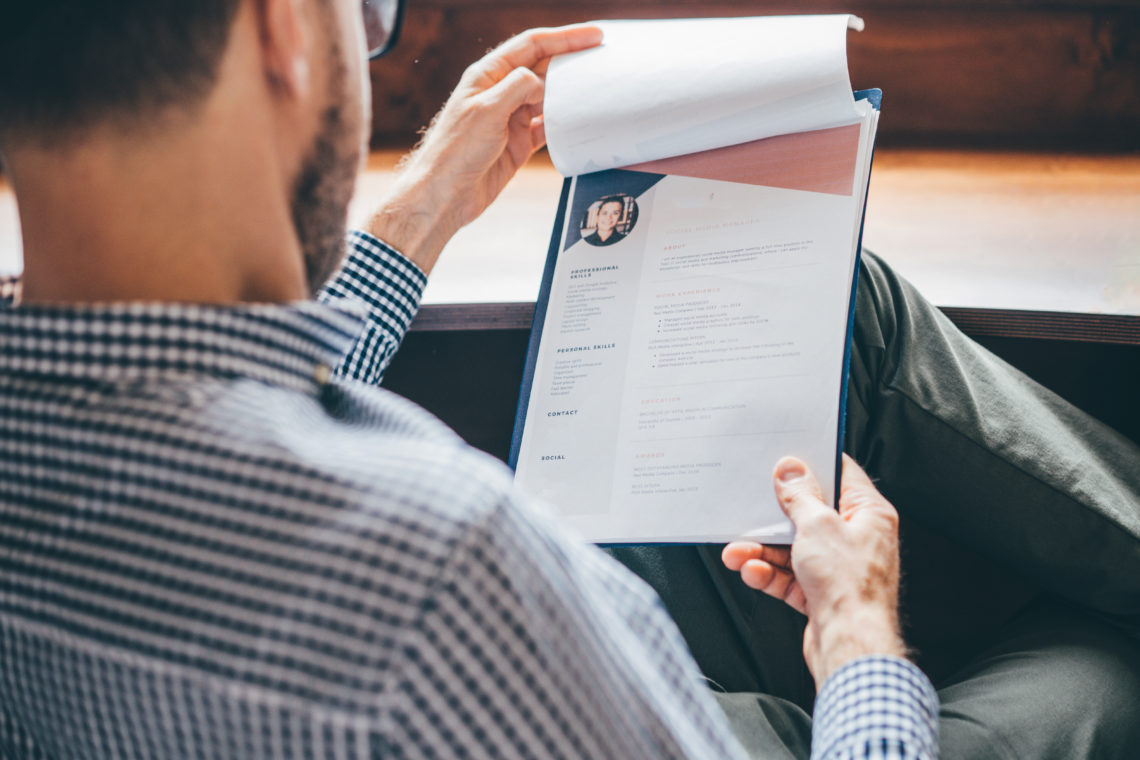 Businessman or HR Manager is reviewing Resume information.