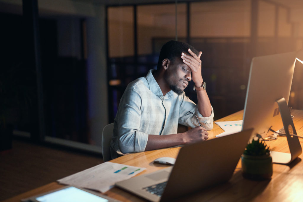 Burnout, night or black man with headache in office for computer 404 glitch, coding anxiety or mental health. Sad, tired or developer on tech for programming depression, work stress or software fail